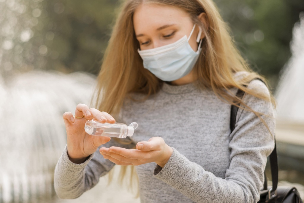 zensina-v-medicinskoi-maske-sida-radom-s-fontanom.jpg
